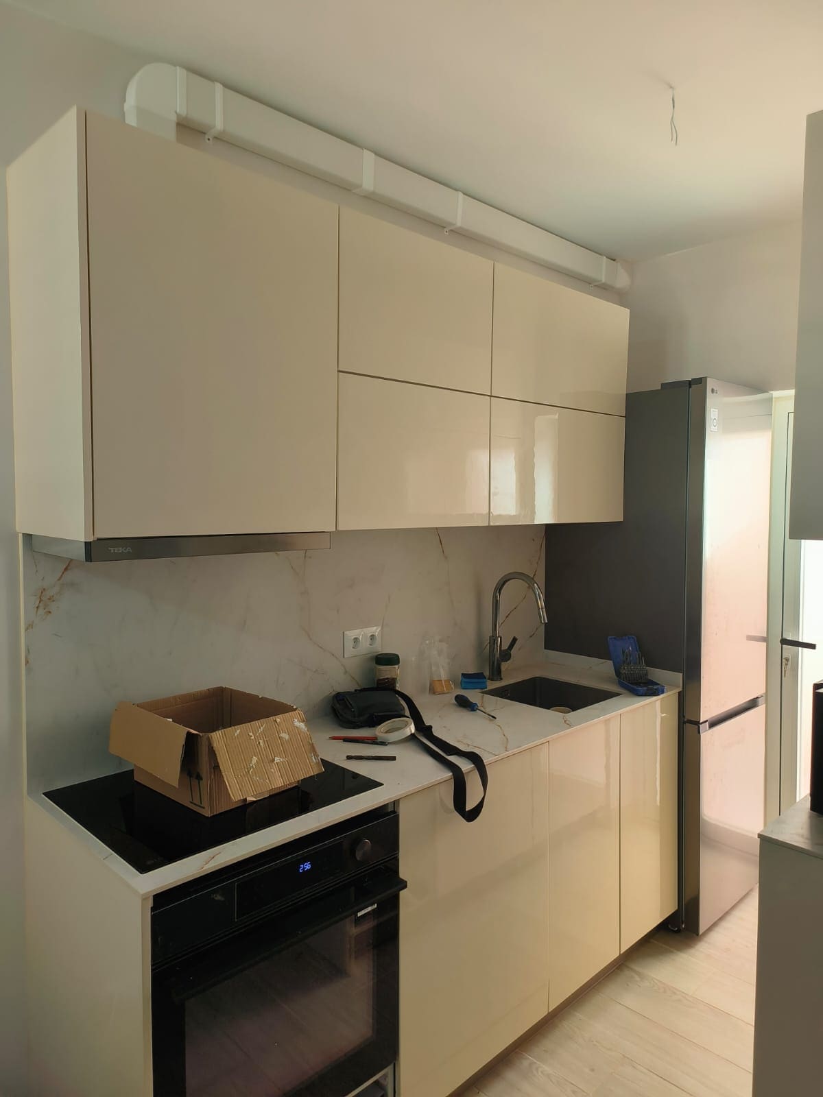 Cocina reformada en Calpe con módulos bajos y altos blancos, horno, placa y fregadero